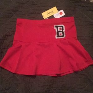 Red pleated skirt, “B”